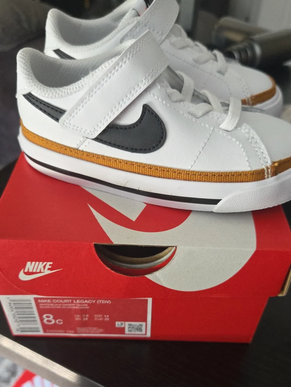 Nike Kids White Sneakers with Black Swoosh and Gold Accent